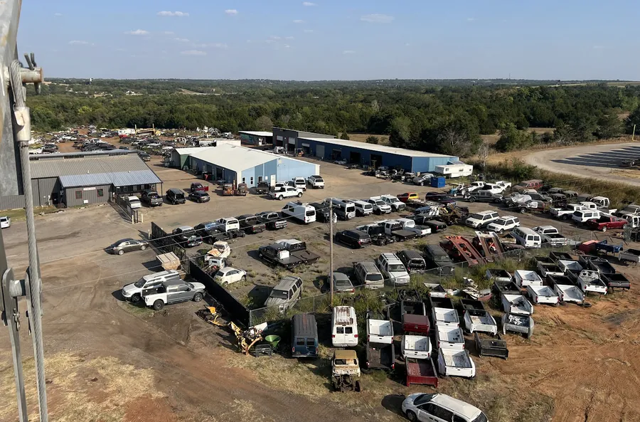 Aerial view of the Cars and Parts by Tim yard in Guthrie, Oklahoma — shop buildings, parts warehouse and rows of vehicles