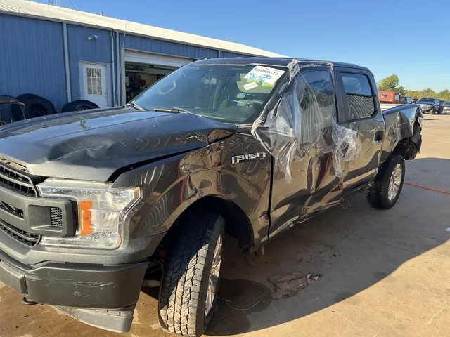 A late-model wrecked Ford F-150 newly tagged with an inventory number