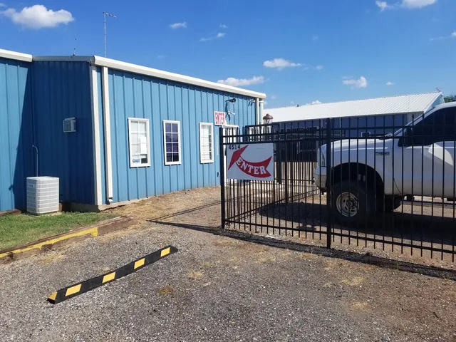 The iron entrance gate and ENTER sign at the CAP yard